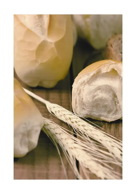Stilleven van verse witte broodjes en tarwearen op een houten tafel
