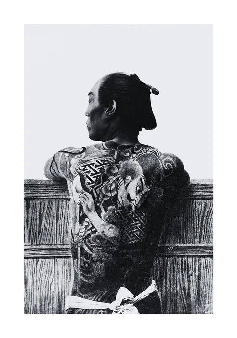 Zwart-witfoto van een Japanse man met traditionele tatoeages op zijn rug.