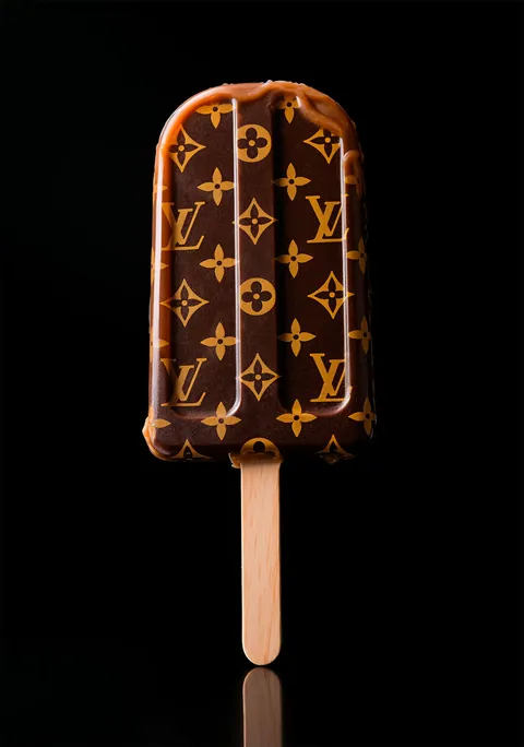 Chocolade-ijsje op een stokje met Louis Vuitton monogram tegen een zwarte achtergrond.