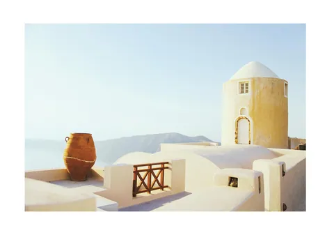 Witte en gele Griekse architectuur op Santorini met terracotta vaas en blauwe lucht
