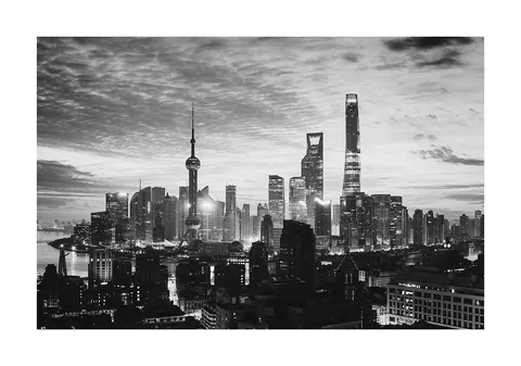 Zwart-witfoto van de wolkenkrabbers en skyline van Shanghai met dramatische wolkenlucht.