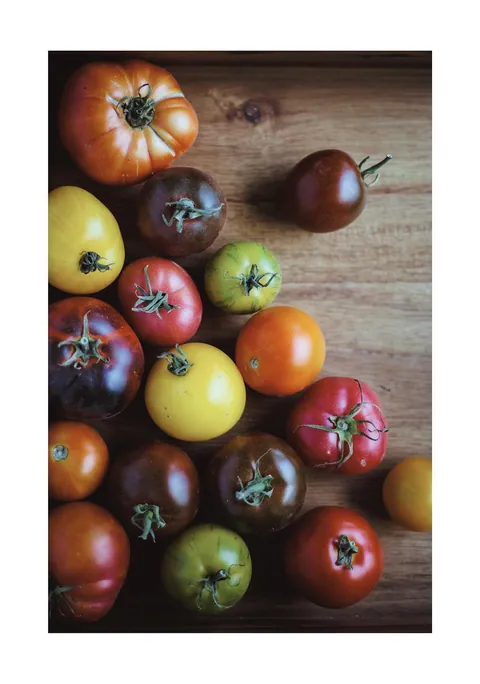 Diverse rode, gele en groene tomaten op een houten ondergrond van bovenaf gefotografeerd