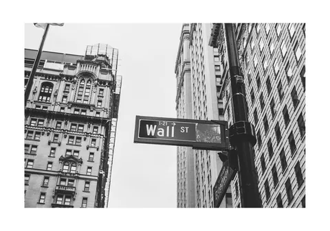 Zwart-witfoto van het Wall Street straatnaambord tussen New Yorkse gebouwen