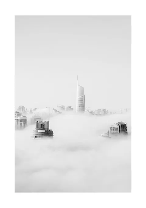 Zwart-witfoto van toppen van moderne wolkenkrabbers die boven een dik wolkendek uitsteken